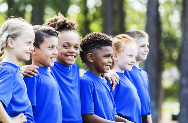 A group of six multi-ethnic children 6-7 years old playing at summer camp.