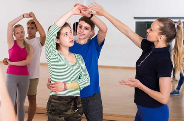 girl and boy dancing with dance instructor with ponytail