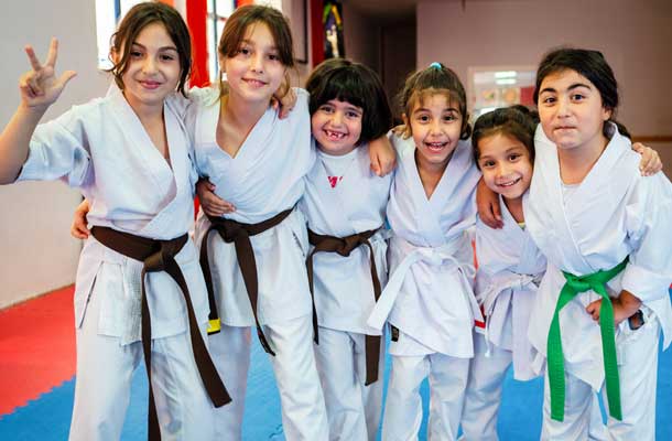 Six children in a martial arts school smiling